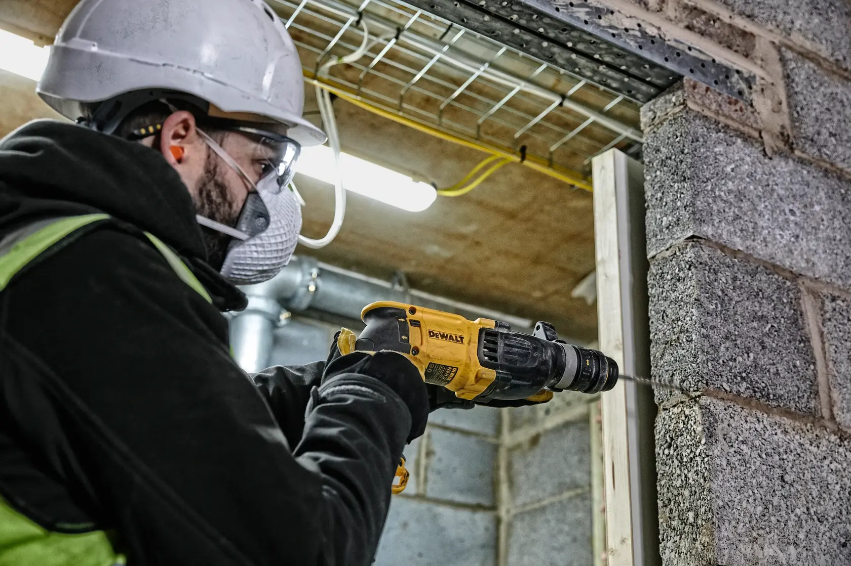 Photo of worker using DEWALT drill, SKUs D25134K-B3, D25134K, D25134K-B2C, D25134K-B2, drilling into wall.