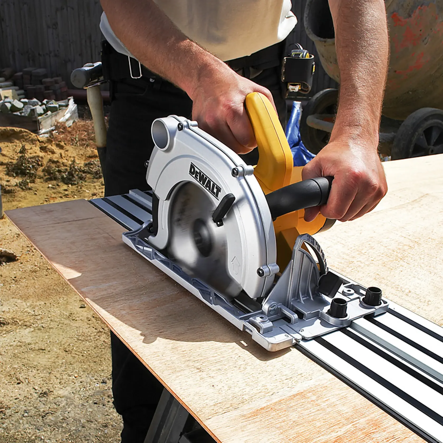 Persona cortando madera con sierra circular DEWALT sobre guía en una mesa al aire libre.